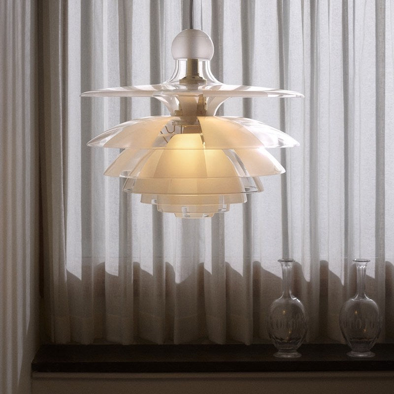 The seven-shade glass crown emits a glare-free, downwardly directed light while radiating a pleasantly delicate glow. Frosted glass fields alternately cover the clear ones from shade-to-shade, thus diffusing the light even more softly.