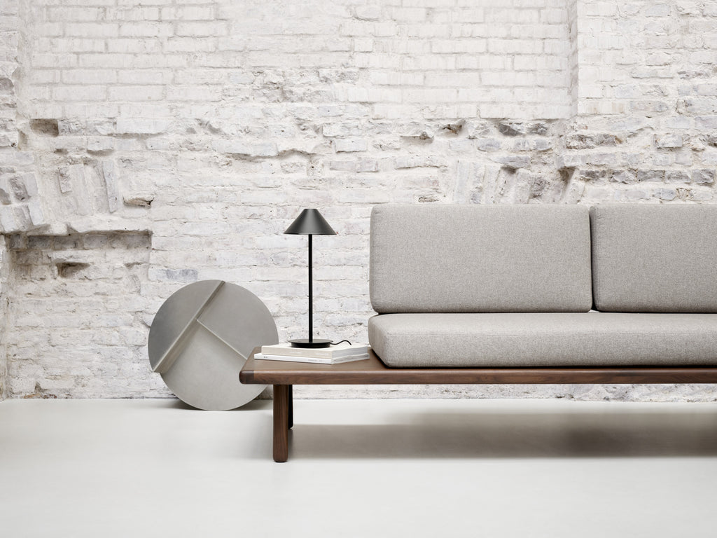 The Keglen table lamp’s distinctive conical shade has a built-in curved diffuser. This ensures an attractive and glare-free downwardly directed light. The stem morphs into the diffuser shade, folding inward and creating a beautiful organic geometry. A gentle light is also emitted upward through a discreet uniform opening in the top of the shade to create a perfect ambiance. Designed by Jakob Lange.