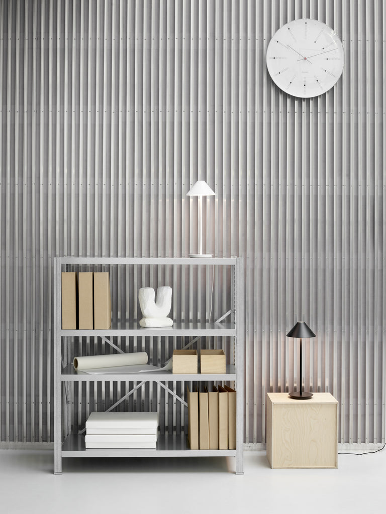 The Keglen table lamp’s distinctive conical shade has a built-in curved diffuser. This ensures an attractive and glare-free downwardly directed light. The stem morphs into the diffuser shade, folding inward and creating a beautiful organic geometry. A gentle light is also emitted upward through a discreet uniform opening in the top of the shade to create a perfect ambiance. Designed by Jakob Lange.