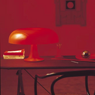 The Nesso Table Lamp from Artemide in orange in a living room.