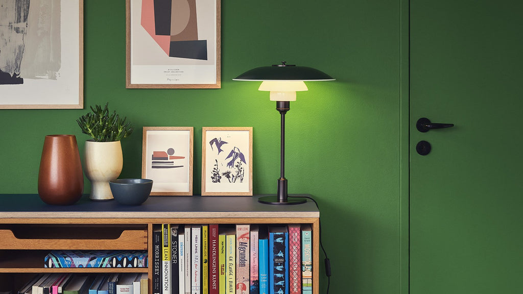 The PH 3½-2½ table lamp is designed based on the principle of a reflective three-shade system, which directs the majority of the light downwards. The shades are made of mouth-blown opal three-layer glass, which is glossy on top and sandblasted matt on the underside, giving a soft and diffuse light distribution. Designed by Poul Henningsen.