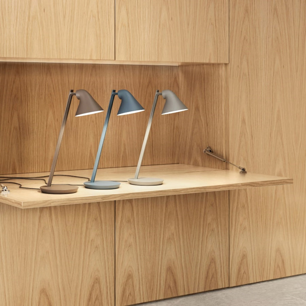 The NJP Mini Table Lamp is a petite version of the NJP Table Lamp with downscaled proportions. Both are a modernistic take on the classic architect lamp with the flexibility of two joints on the extensive arm. The characteristic rear-shade opening toward the arm allows stemless adjustment of the organic head. Designed by Nendo Japanese design studio and designer Oki Sato. 